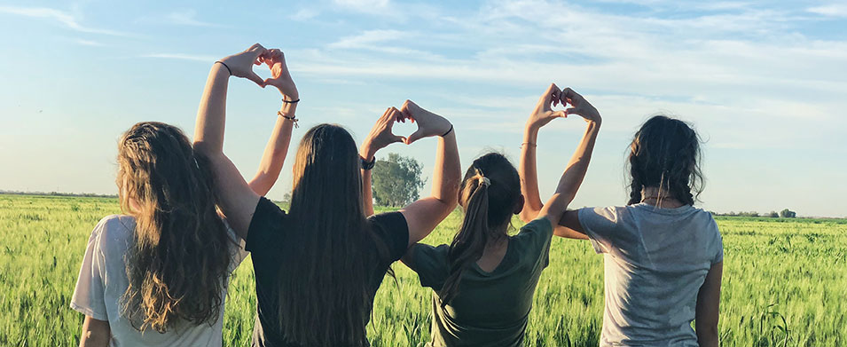 Spenden - vier Mädchen zeigen mit ihren Händen Herzen